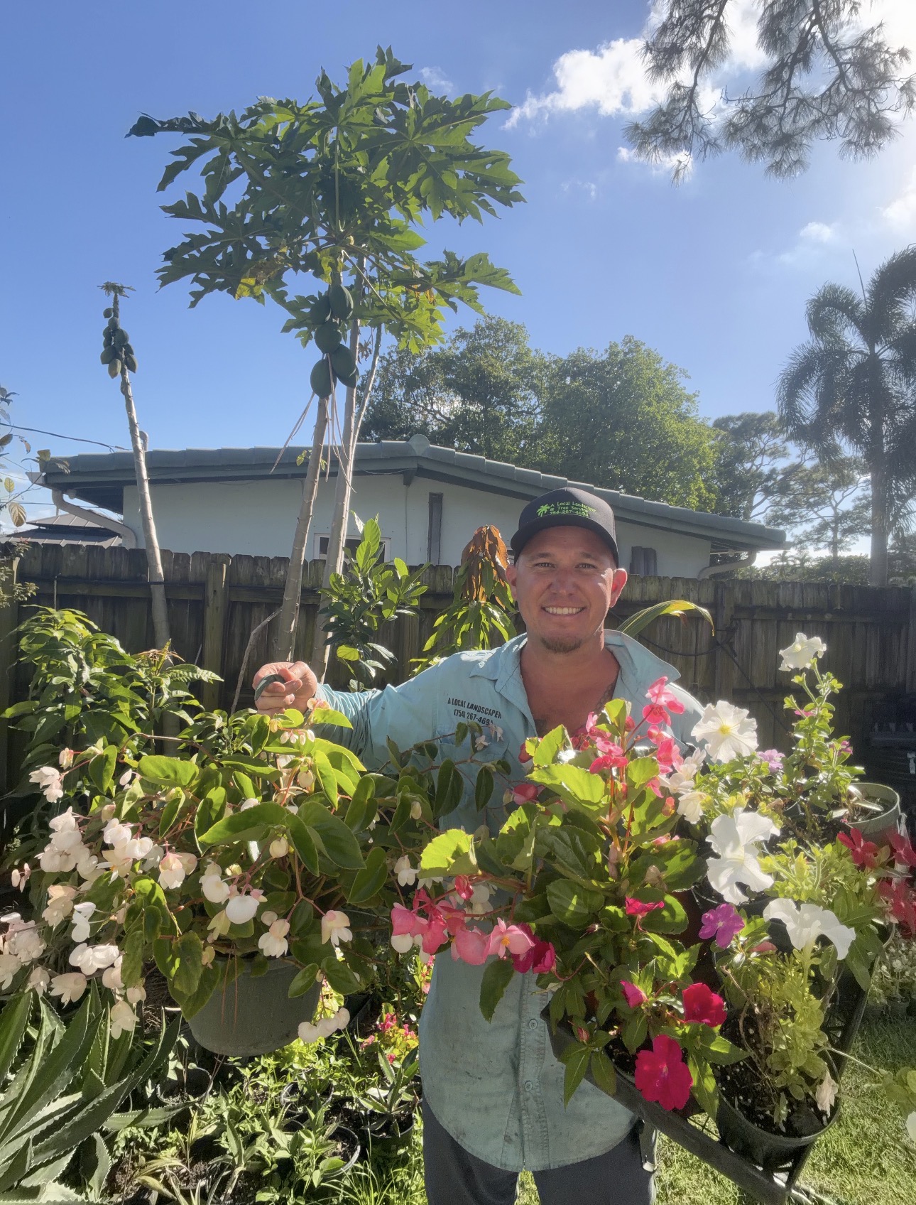 Derek, owner of A Local Landscaper & Tree Service, with flowering plants on a job site